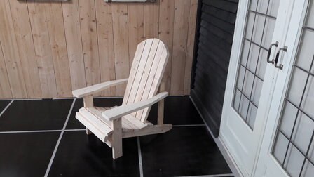 Adirondack chair op een terras voor een deur