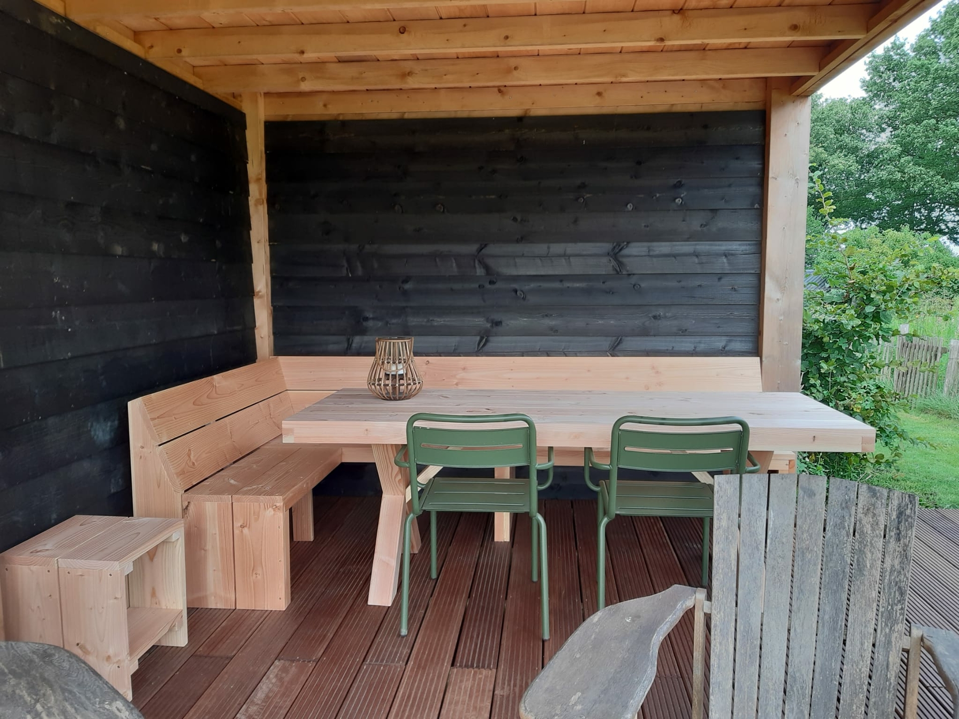 Houten douglas tafel met een hoekbank er achter van douglas hout