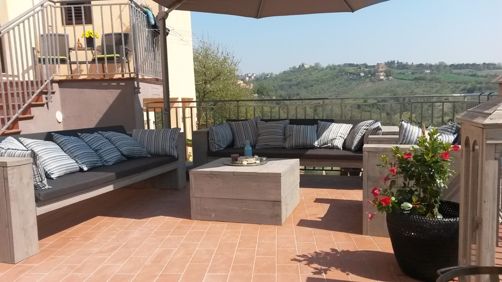 Steigerhout loungeset met kussens op een terras in italie met mooi uitzicht