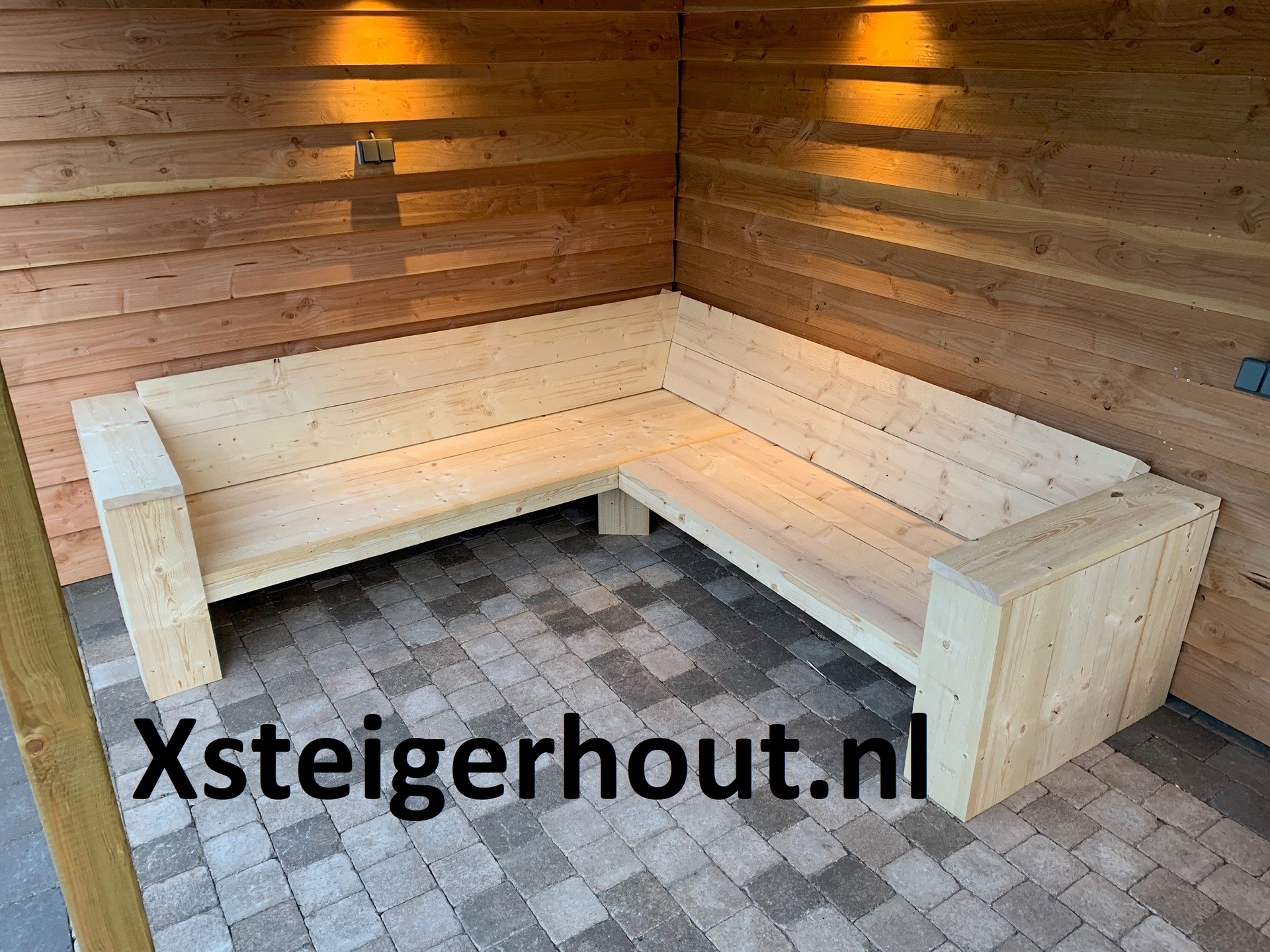 Hoekbank steigerhout onder een overkapping 