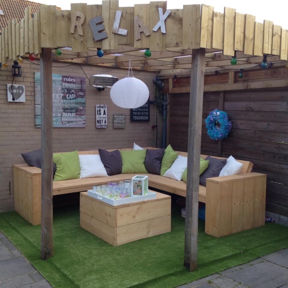 Hoekbank steigerhout met tafel onder een pergola overkapping